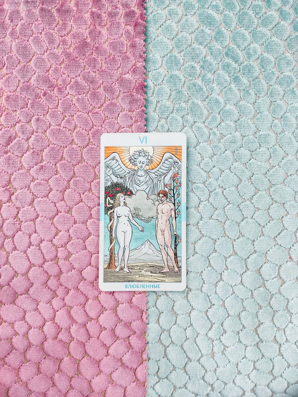 two colored fabric with a tarot card known as the lovers in the middle.